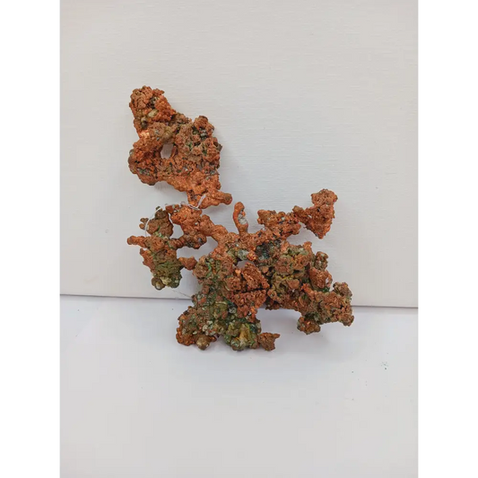Raw copper specimen with bright metallic luster and unique natural formations, displayed on a white background.