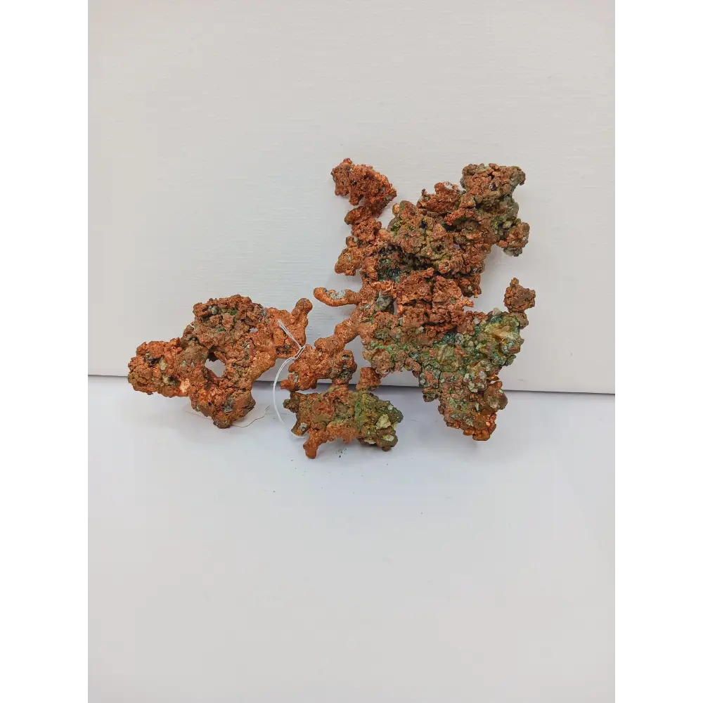 Raw copper specimen with bright metallic luster and unique natural formations, displayed on a white background.
