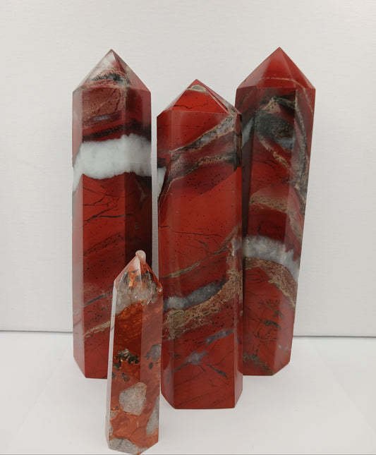 Hand-carved Red Jasper point with a clear quartz band, featuring vibrant red tones and a striking clear quartz stripe, displayed on a white background.