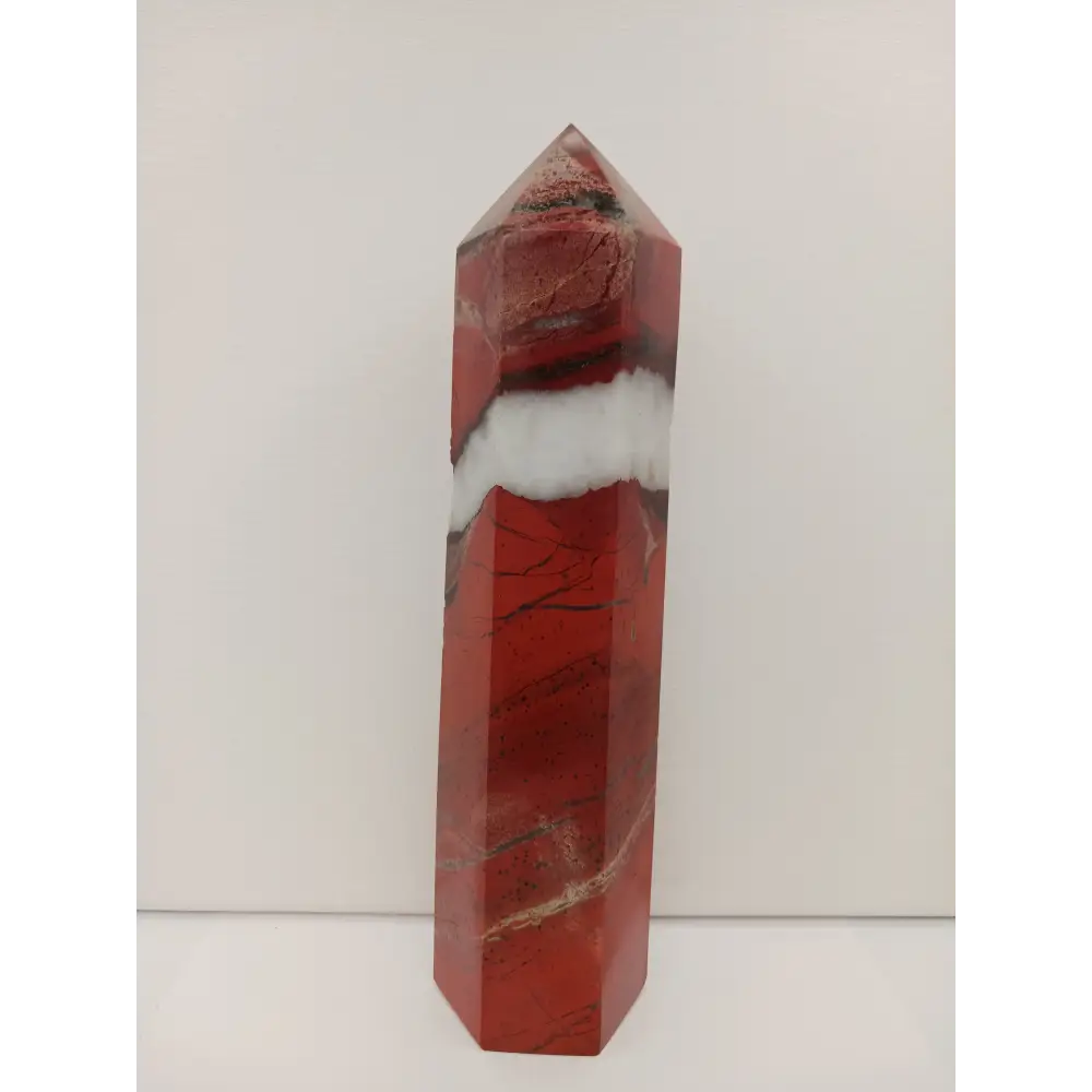Hand-carved Red Jasper point with a clear quartz band, featuring vibrant red tones and a striking clear quartz stripe, displayed on a white background.