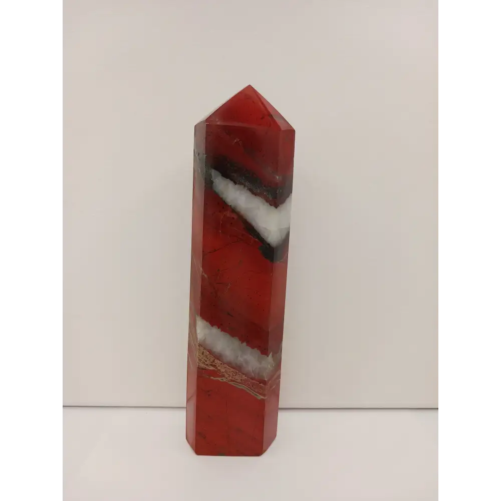 Hand-carved Red Jasper point with a clear quartz band, featuring vibrant red tones and a striking clear quartz stripe, displayed on a white background.