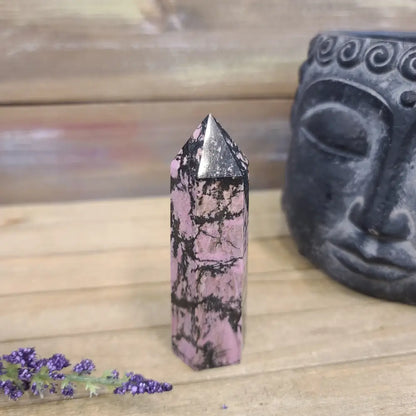 Hand-carved Rhodonite tower featuring vibrant pink hues with bold black veining, displayed on a white background.
