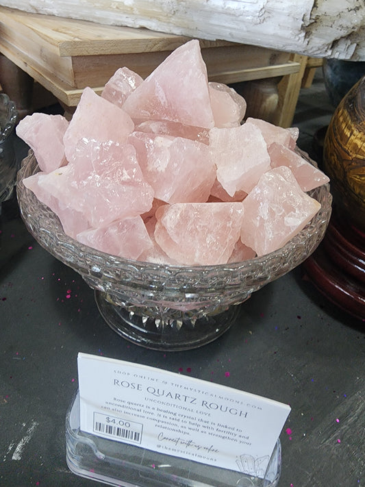 Raw rose quartz crystal with soft pink hues and natural, rough texture, displayed on a white background. Perfect for heart healing, love, and emotional balance.