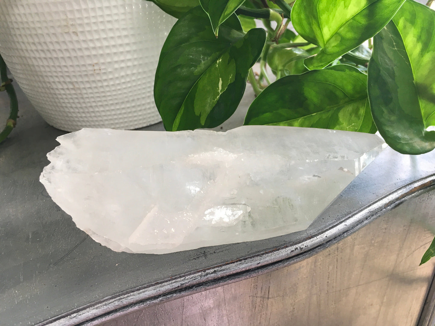 Natural rough quartz point crystal with clear, unpolished surfaces and unique shape, displayed on a white background. Perfect for energy amplification, cleansing, and spiritual work.