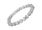 A white selenite bracelet with round beads laid out on a black surface.