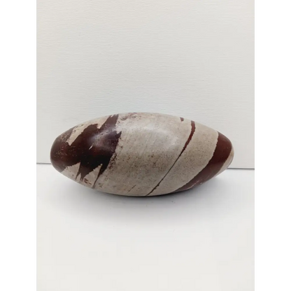 Shiva Lingam stones, polished with natural earthy patterns, available in sizes 1" to 8", displayed on a white background.