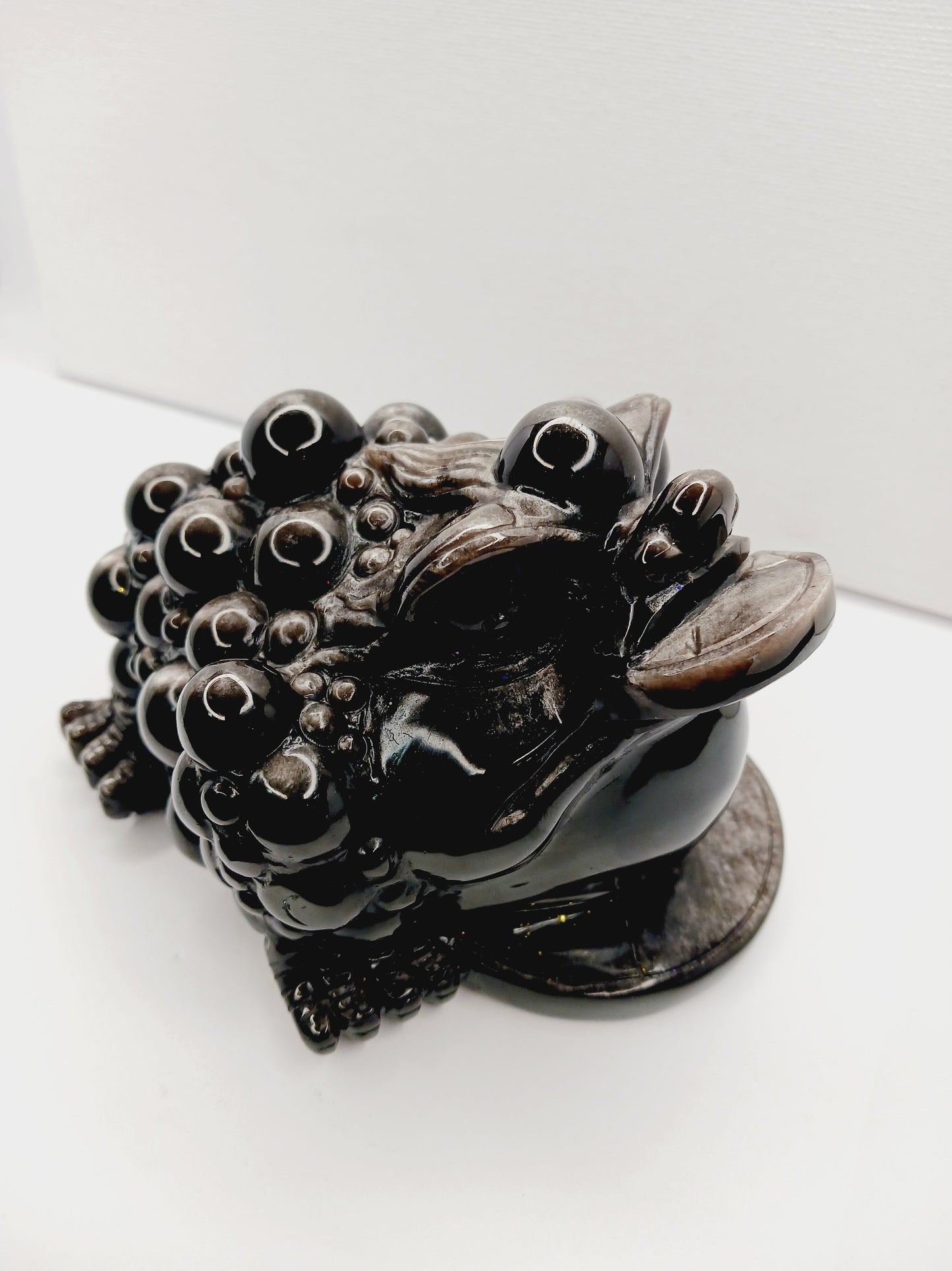 Silver sheen obsidian money toad, hand-carved with a reflective silver luster, measuring 5.5 inches, displayed on a white background.