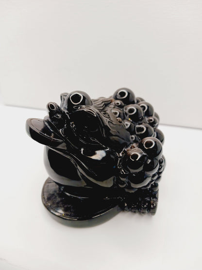 Silver sheen obsidian money toad, hand-carved with a reflective silver luster, measuring 5.5 inches, displayed on a white background.