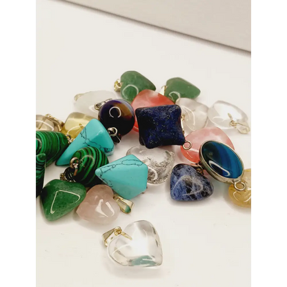 Assorted small stone pendants, each with polished gemstones in various colors and shapes, displayed on a white background.