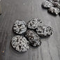 Hand-polished snowflake obsidian hearts and palmstones, featuring black stone with white snowflake patterns, displayed on a white background. Perfect for grounding, protection, and gentle transformation.