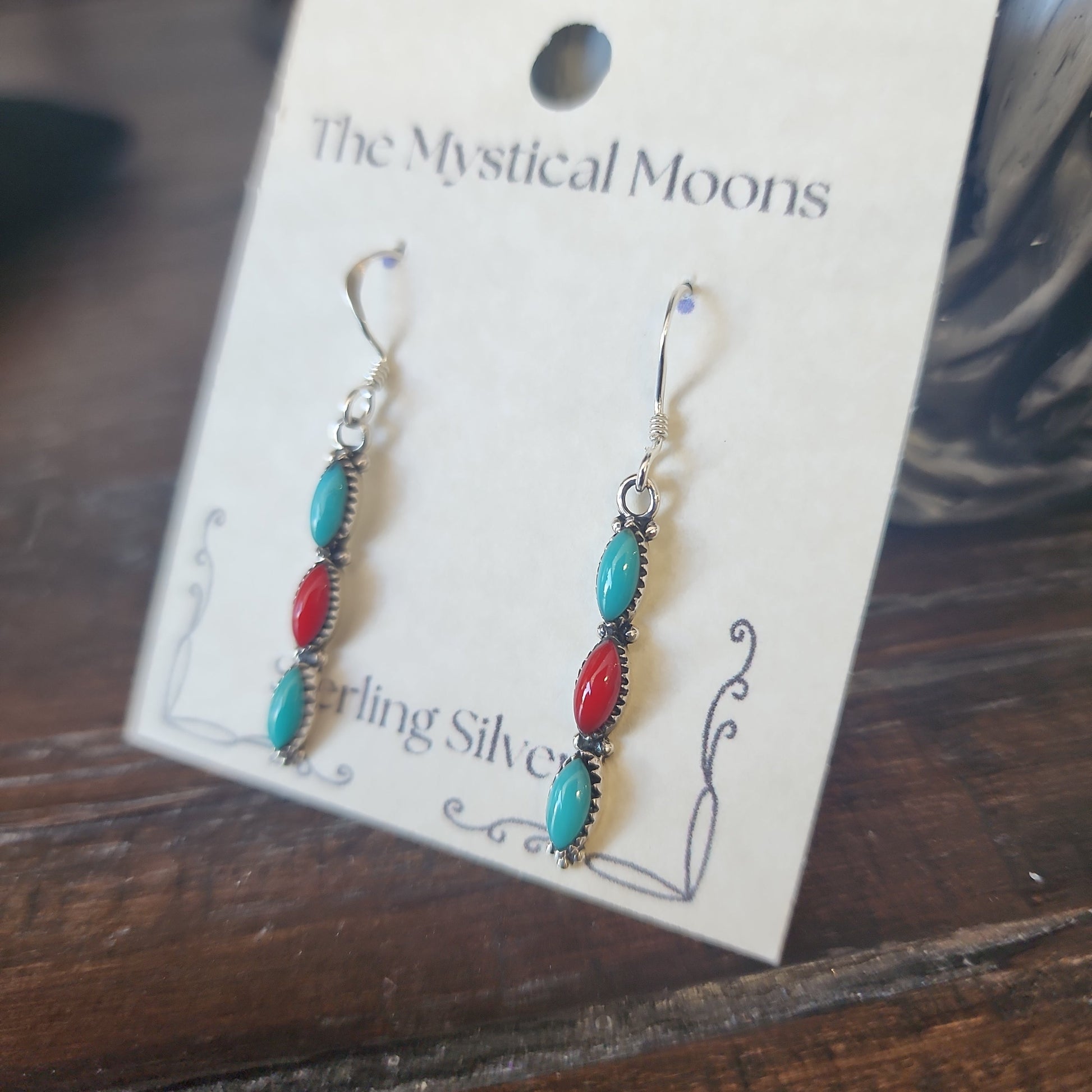Sterling silver earrings with Southwest-inspired design featuring vibrant turquoise stones, displayed on a white background. Perfect for protection, wisdom, and desert magic.