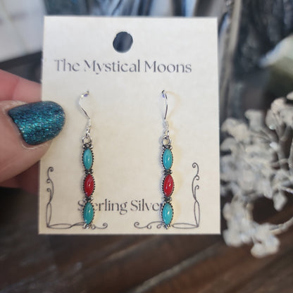 Sterling silver earrings with Southwest-inspired design featuring vibrant turquoise stones, displayed on a white background. Perfect for protection, wisdom, and desert magic.