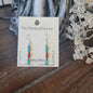 Sterling silver earrings with Southwest-inspired design featuring vibrant turquoise stones, displayed on a white background. Perfect for protection, wisdom, and desert magic.