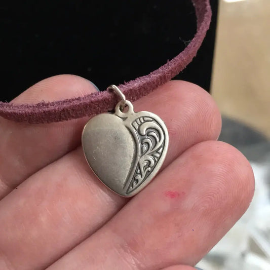 Sterling silver heart pendant with a classic, polished finish, displayed on a white background. Perfect for love, compassion, and timeless elegance.