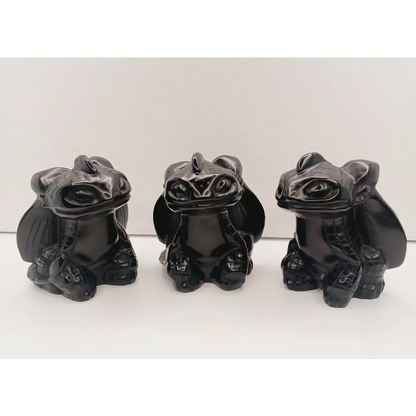 Toothless dragon carving, 3.5 inches, hand-carved from glossy black obsidian, displayed on a white background.