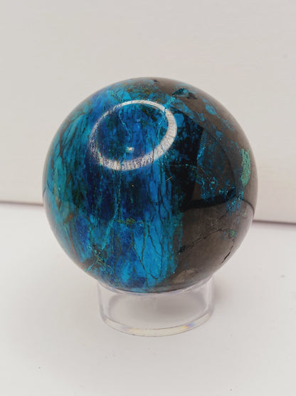 Turquoise sphere with vibrant blue-green color and natural veining, displayed on a white background.