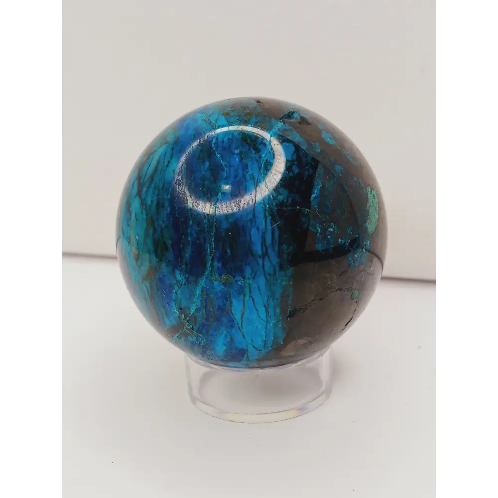 Turquoise sphere with vibrant blue-green color and natural veining, displayed on a white background.