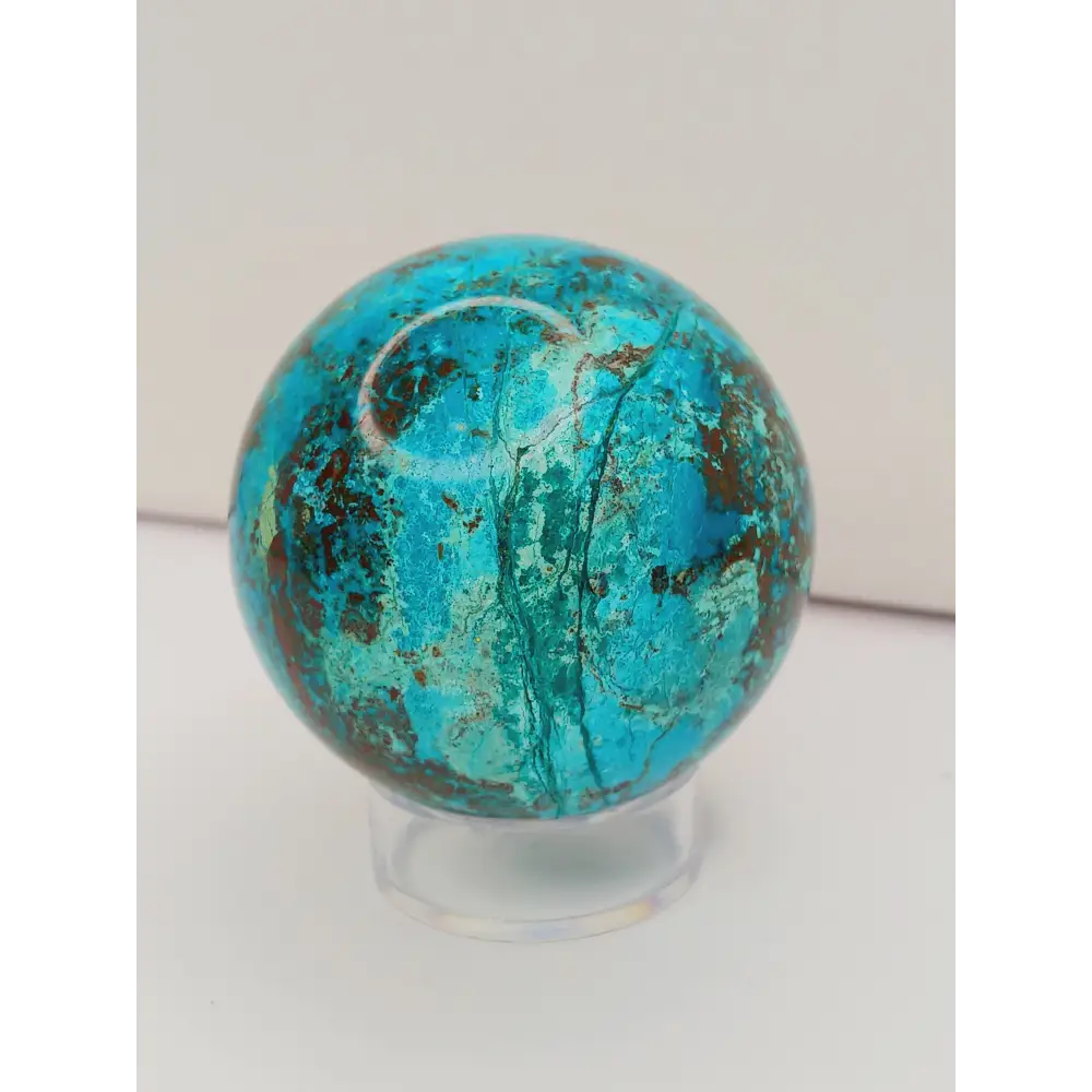 Turquoise sphere with vibrant blue-green color and natural veining, displayed on a white background.