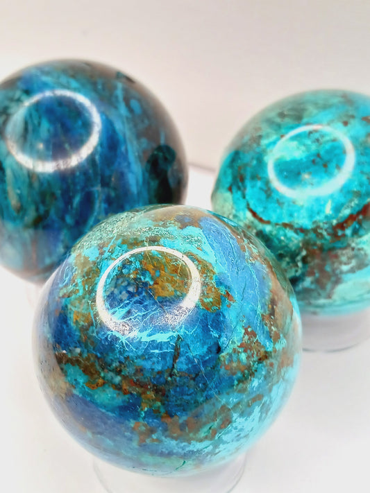 Turquoise sphere with vibrant blue-green color and natural veining, displayed on a white background.