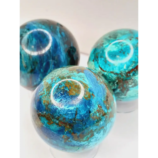 Turquoise sphere with vibrant blue-green color and natural veining, displayed on a white background.
